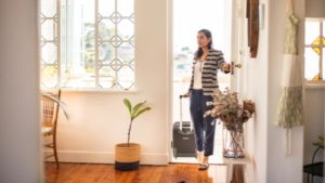 conciergerie airbnb - Une femme avec une valise entrant dans un logement