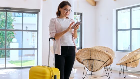 carte g conciergerie - une femme avec une valide debout au milieu d'une pièce avec son téléphone portable dans les mains